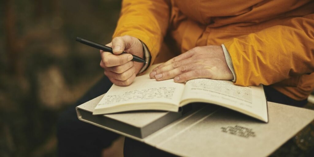 Une personne écrivant un livre avec un stylo, pour symboliser le 5e art