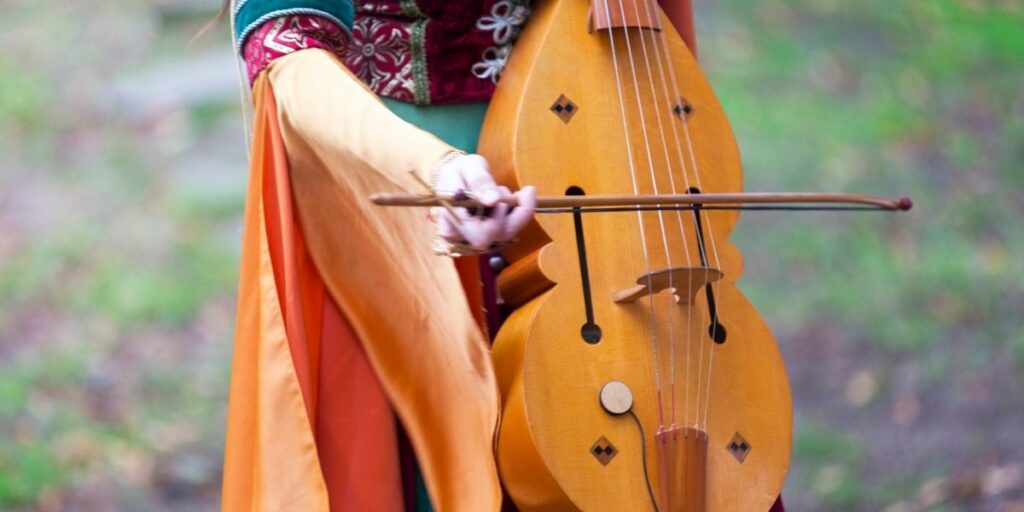 Une femme joue de la musique dans les Médiévales de Bayeux